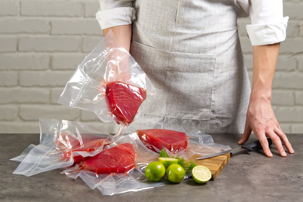 A person holding pieces of salmon that have been vacuum packaged. 