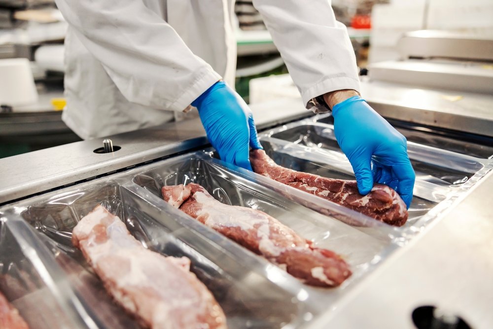 A person prepping meat to be vacuum packaged to increase the shelf life.