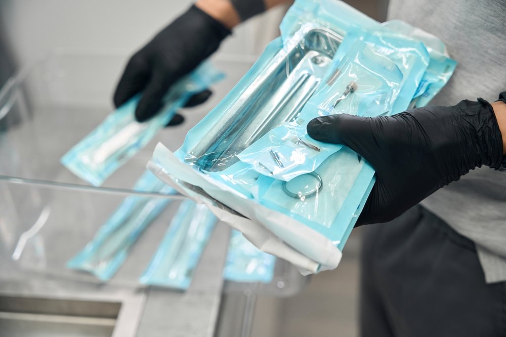 A person holding vacuum sealed medical equipment.